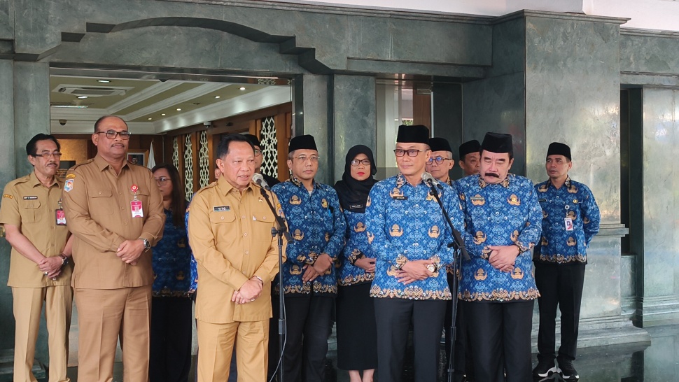 Menteri Dalam Negeri Tito Karnavian (kiri) bersama Ketua Umum Dewan Pengurus Korpri Nasional Zudan Arif Fakrulloh (kanan) menyampaikan sambutan dalam acara penyerahan simbolis bantuan lima unit ambulans untuk mendukung percepatan rehabilitasi dan rekonstruksi daerah terdampak bencana di Sumatera di Kantor Kementerian Dalam Negeri, Jakarta, Senin (13/7/2026). (Suara.com/Mohammad Rhadzaki Ramadhan)