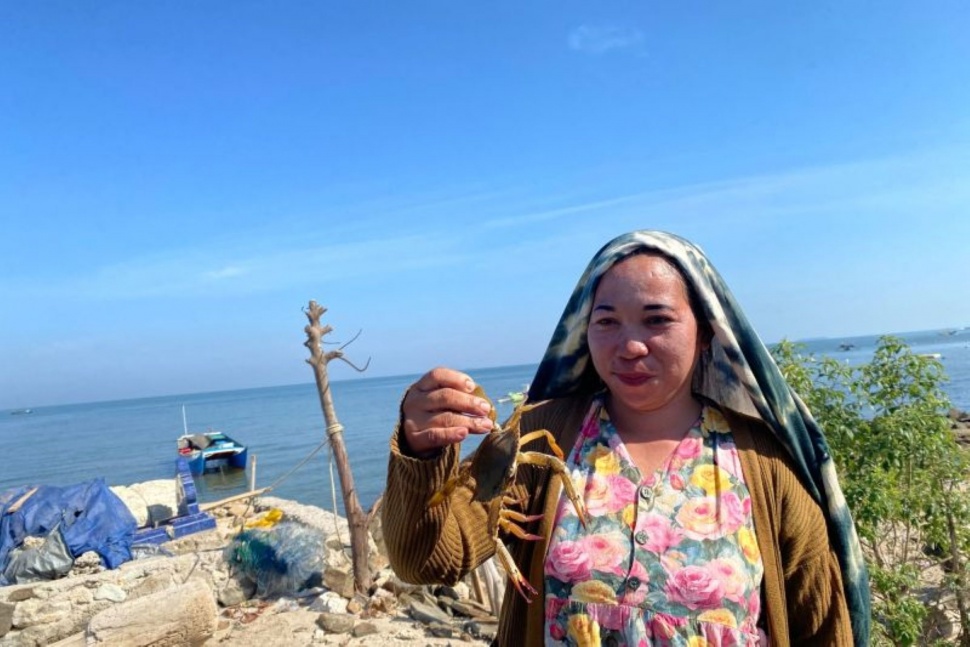 Warga Dusun Kure Caddi bernama Irma memperlihatkan kepiting dari hasil tangkapan sang suami di Desa Nisombalia, Kabupaten Maros, Sulawesi Selatan. ANTARA/Nur Suhra Wardyah (B)
