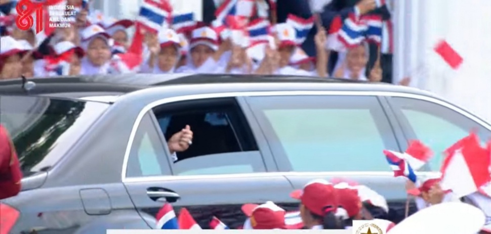 Perdana Menteri (PM) Thailand Anutin Charnvirakul membalas sambutan pelajar dengan membuka kaca mobilnya sambil menunjukkan gestur jari berbentuk hati di Istana Merdeka, Jakarta, Senin (3/8/2026). [Suara.com/Bagaskara]