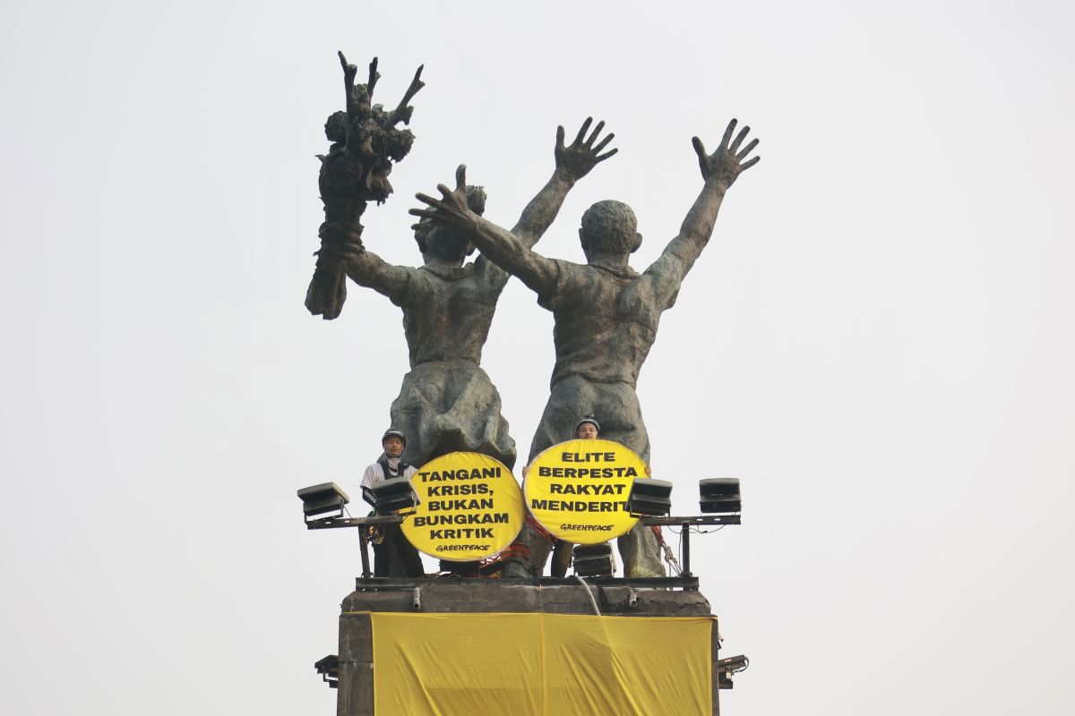 Sejumlah ktivis Greenpeace Indonesia membentangkan dua spanduk raksasa dari puncak Patung Selamat Datang di Bundaran Hotel Indonesia, Jakarta Pusat, Selasa (20/10/2026). Spanduk itu berisi tulisan protes terhadap pemerintahan Prabowo-Subianto yang membiarkan krisis ekologi serta krisis ekonomi. [Dhemas Reviyanto/Greenpeace]