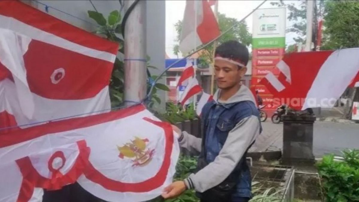 Aman penjual Bendara asal Bandung yang merantau ke Bali untuk memanfaatkan momen 17 Agustus 2022. Aman menjua bendera dengan omzet yang cukup besar. [Suara.com / Putu Yonata Udawananda]