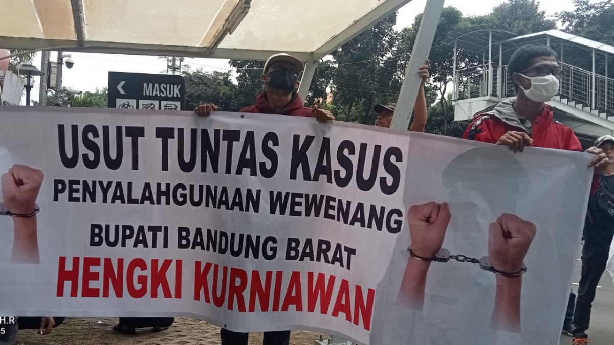 Massa aksi membawa pamplet protes [(Foto: Jajang)]