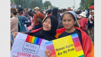 MIRIS! Perempuan Berjilbab Mengibarkan Bendera Pelangi di Monas, Netizen: Dibayar Berapa?