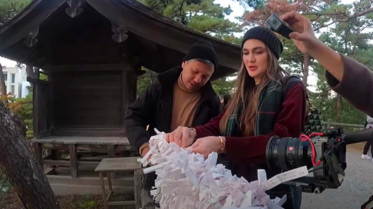 Luna Maya dan gading Marten saat mengikat ramalan kertas. Keduanya dapat ramalan kurang baik [Foto: Tangkapan Layar Youtube Luna Maya]