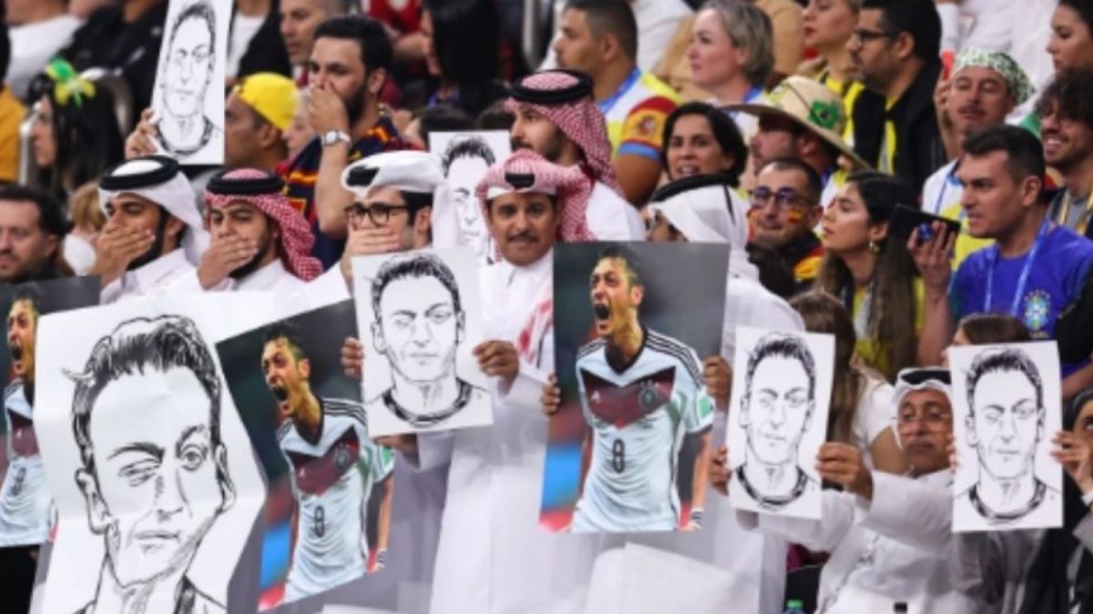 Suporter Bawa Foto Mesut Ozil ketik Jerman Vs Spanyol. Banyak yang mengatakan kegagalan Jerman akibat dosa perlakuan kepada Ozil [Foto: THE SUN]