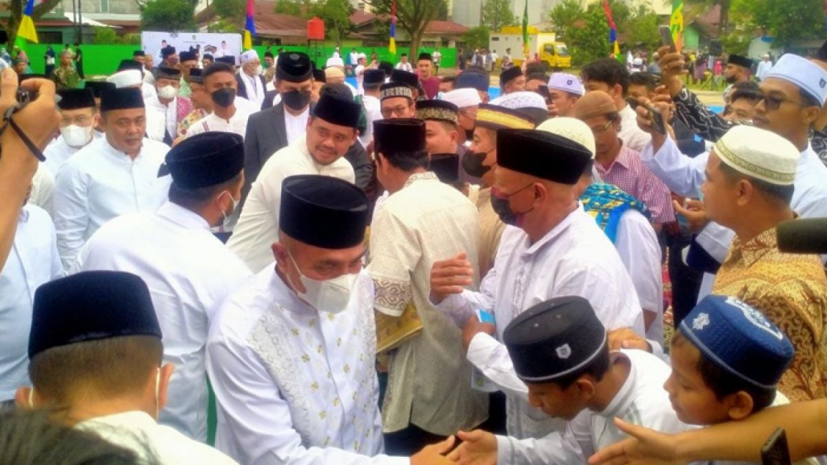Gubernur Sumut Edy Rahmayadi dan Wali Kota Medan Bobby Nasution menyalami masyarakat usai  menunaikan salat Idul Adha di Lapangan Gajah Mada Medan, Minggu (10/7/2022). [Deli.Suara.com]