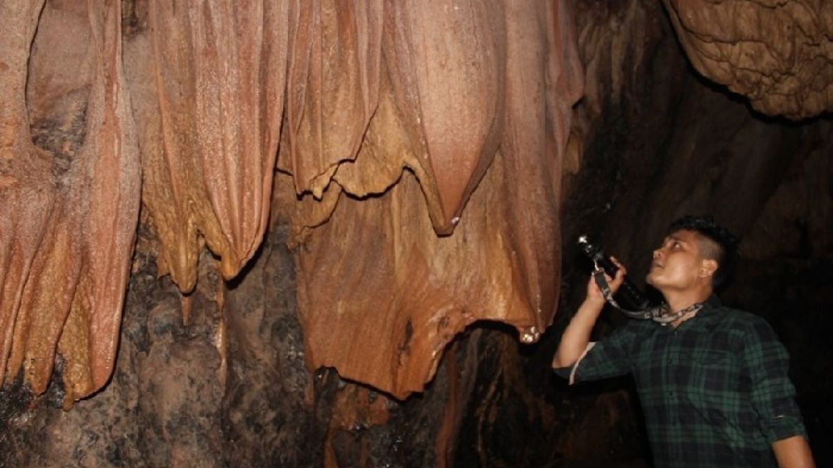 Salah seorang pengunjung melihat eksotisnya Gua Air di Batu Katak. [Beni Nasution/Suara Deli.]