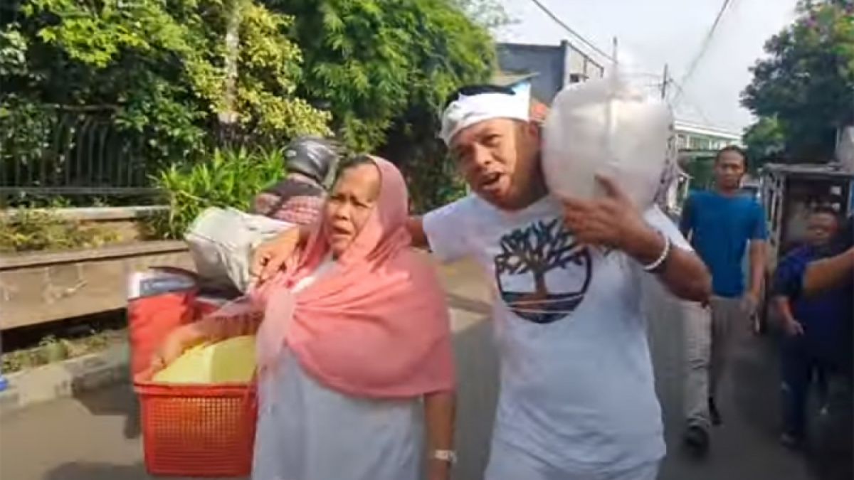 Kang Dedi Mulyadi dan janda Umiyati Utari memanggul beras. [Youtube Kang Dedi Mulyadi Channel]