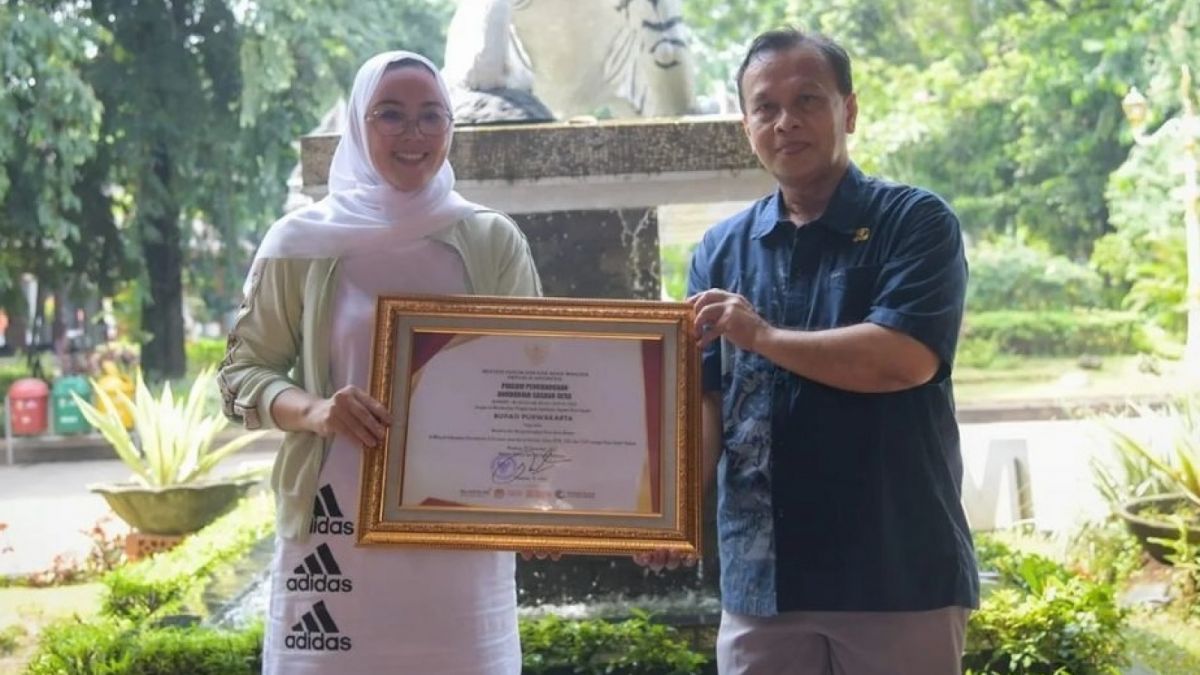 Ambu Anne memegang plakat oenghargaan. [(Instagram @Anneratna82.]