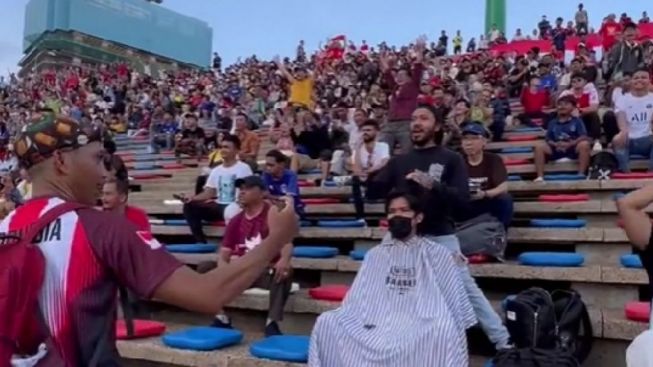 Trending! Aksi Tukang Cukur Pangkas Rambut Pelanggan di Stadion Saat Timnas Indonesia Tanding di SEA Games 2023