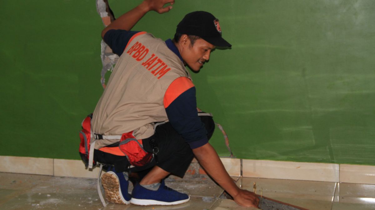 Petugas BPBD ukur kedalaman tanah amblas di dalam rumah [ponorogo.suara.com/dedy.s]