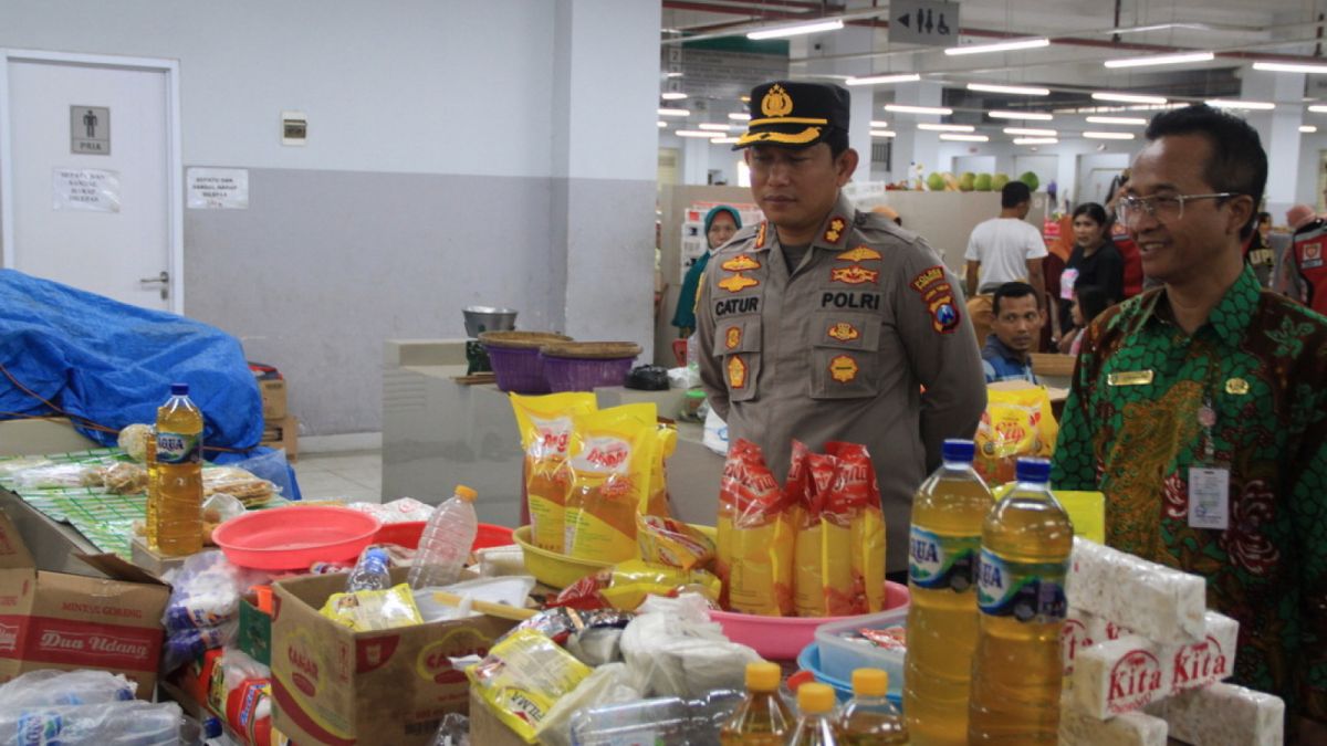 kapolres ponorogo AKBP Catur C. Wibowo. bertanya ke pedagang minyak goreng [ponorogo.suara.com/dedi.s]