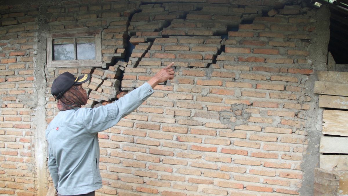 warga menunjuka bangunan rusak parah akibat tanah gerak [ponorogo.suara.com/dedi.s]