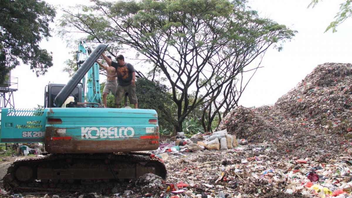 petugas TPA mengecek Eskavator Sewaan [ponorogo.suara.com/dedy.s]