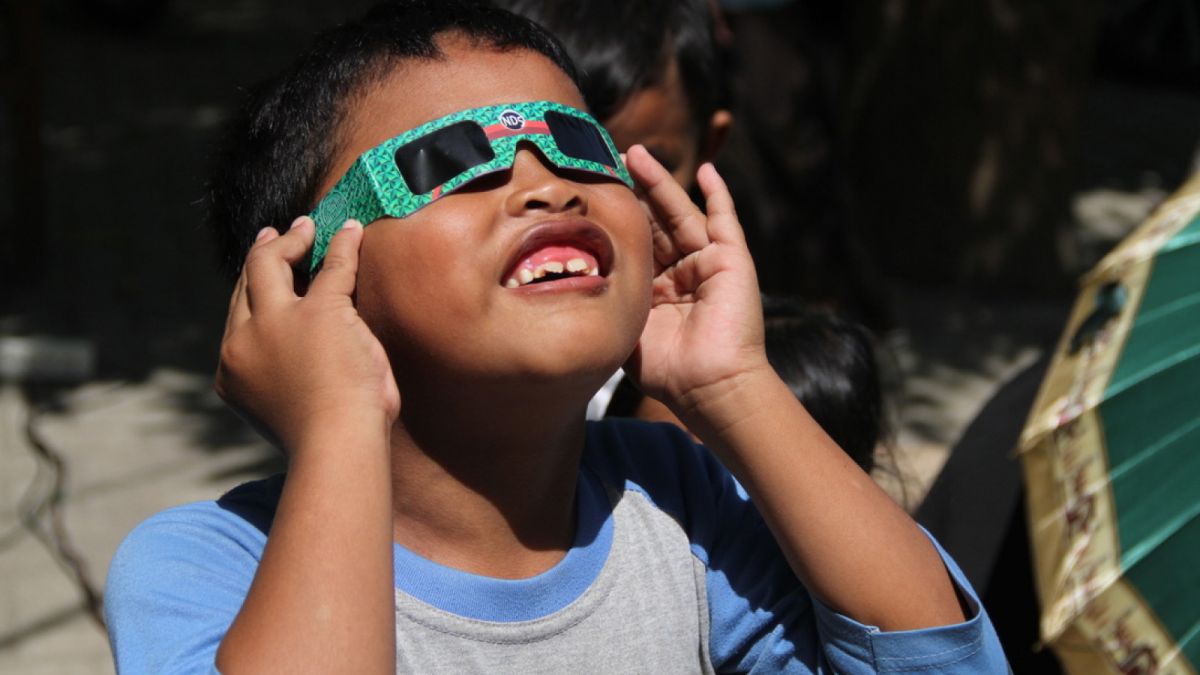 anak anak melihat gerhana matahari dengan kacamata [ponorogo.suara.com/dedy.s]
