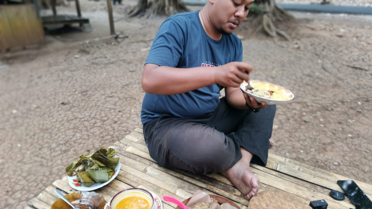 salah satu pelanggan menikmati nasi tiwul [ponorogo.suara.com/dedy.s]