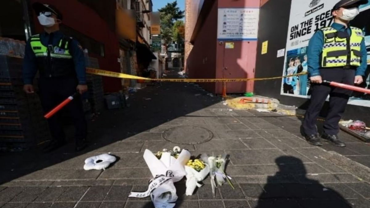 Polisi dan karangan bunga di jalanan Itaewon yang sekarang sepi [The Korea Herald]