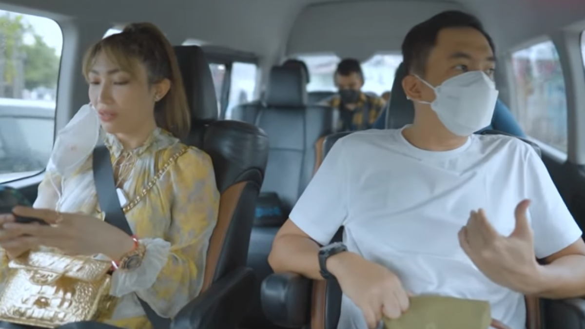 Regi Datau terlihat membawa dompet berwarna krem dengan tali coklat tua yang sama persis dengan foto dompet RD [YouTube Ayu Dewi]