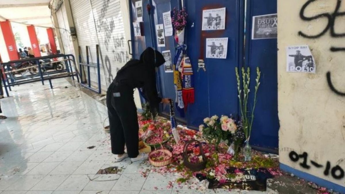 Warga meletakan syal di salah satu gate yang menjadi tempat meregangnya nyawa Aremania [Suara.com/Dimas Angga]