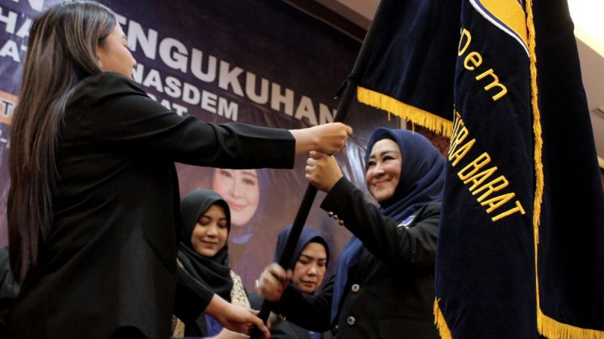 Ketua Garnita Malahayati Nasdem Sumatera Barat, Lisda Hendrajoni menerima pataka dari Wakil Ketua Umum Garnita Malahayati NasDem, Vicky Veranita Yudhasoka (Vicky Shu) di Padang, Sabtu (22/10/2022) [Kariadil Harefa/Suara Serang]