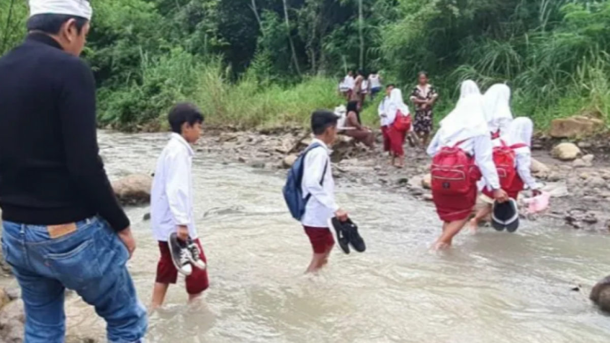 Sejumlah anak sekolah menyeberang sungai untuk bersekolah karena tidak adanya jembatan