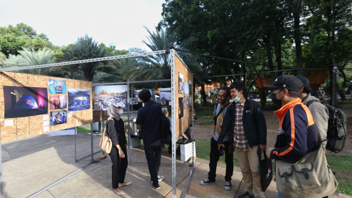 Pengunjung menyaksikan pameran fotografi jurnalistik 'Rekam Jakarta 24+' yang diselenggarakan oleh Pewarta Foto Indonesia Jakarta (PFI) di taman lapangan Banteng, Jakarta, Jumat (28/10/2022). [dok. PFI Jakarta]