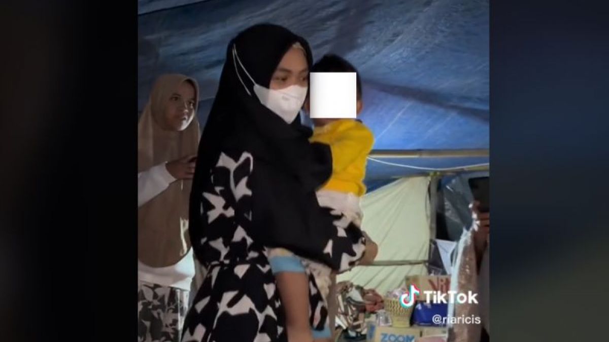 Ria Ricis saat gendong anak dalam tenda pengungsian usai menurunkan bantuan logistik kepada korban terdampak gempa di Cianjur, Jawa Barat [TikTok/@riaricis]