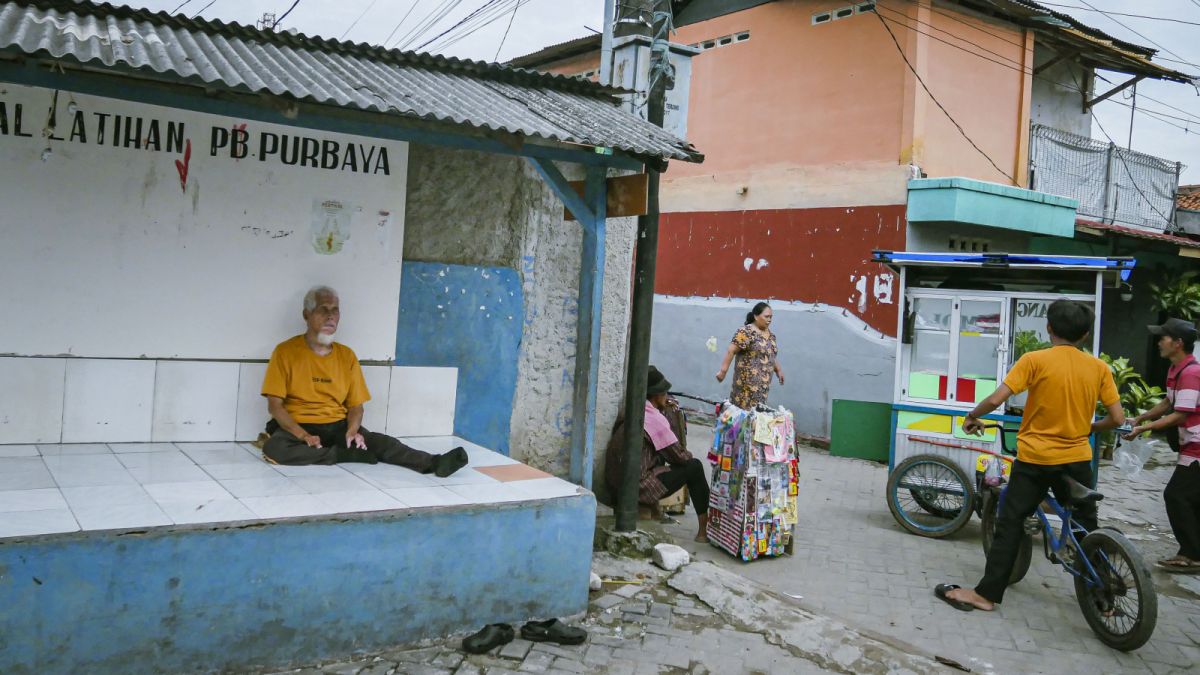 Pak Sumanta (73) sits at the guard post in Leprosy Village, Neglasari, Tangerang City, Banten, Sunday (29/1/2023). [SuaraSerang/Wawan Kurniawan]