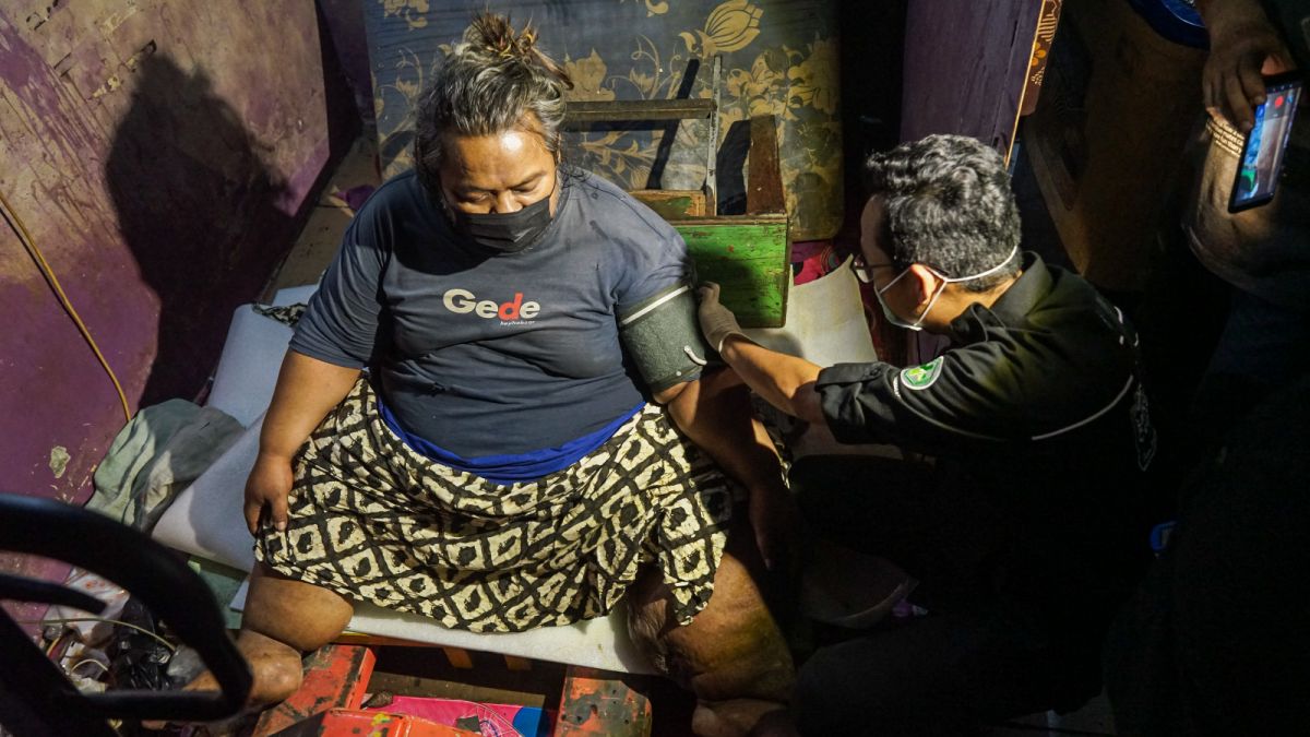 Petugas Medis melakukan pemeriksaan tensi terhadap Cipto Raharjo (45), pria obesitas dengan bobot 200 Kg di rumahnya sebelum dievakuasi ke RSUD Kota Tangerang, Selasa (4/7/2023). [Suara Serang/Wawan Kurniawan]