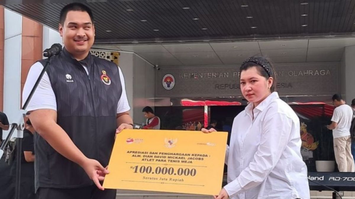 Menpora Dito Ariotedjo menyerahkan penghargaan untuk mendiang David Jacobs yang diwakili sang istri, Jeanny Inggrid Palar di Halaman Kantor Kemenpora, Senayan, Jakarta, Senin (3/7/2023). (ANTARA/Muhammad Ramdan)