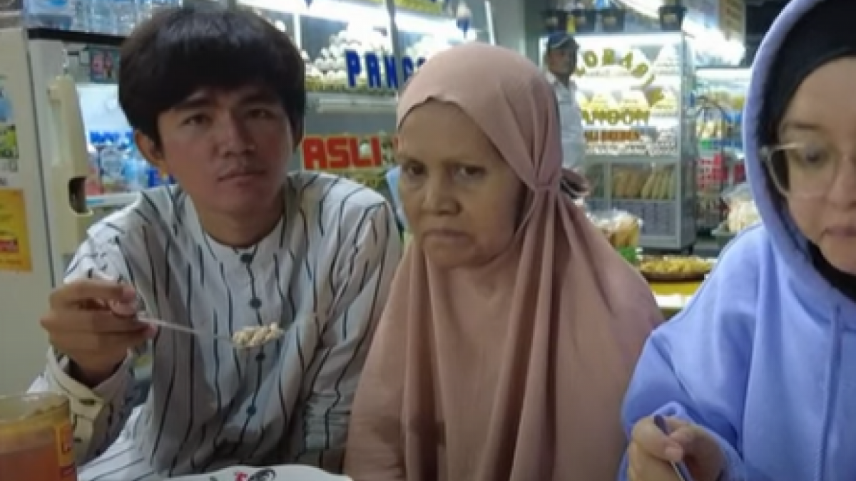 Tiko menyuapi Ibu Eny saat makan di rest area dalam perjalanan menuju Madiun [YouTube/DenDenny]