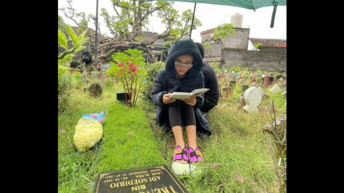 Yuni Shara saat mengaji di makam ayahnya [Instagram/@yunishara36]