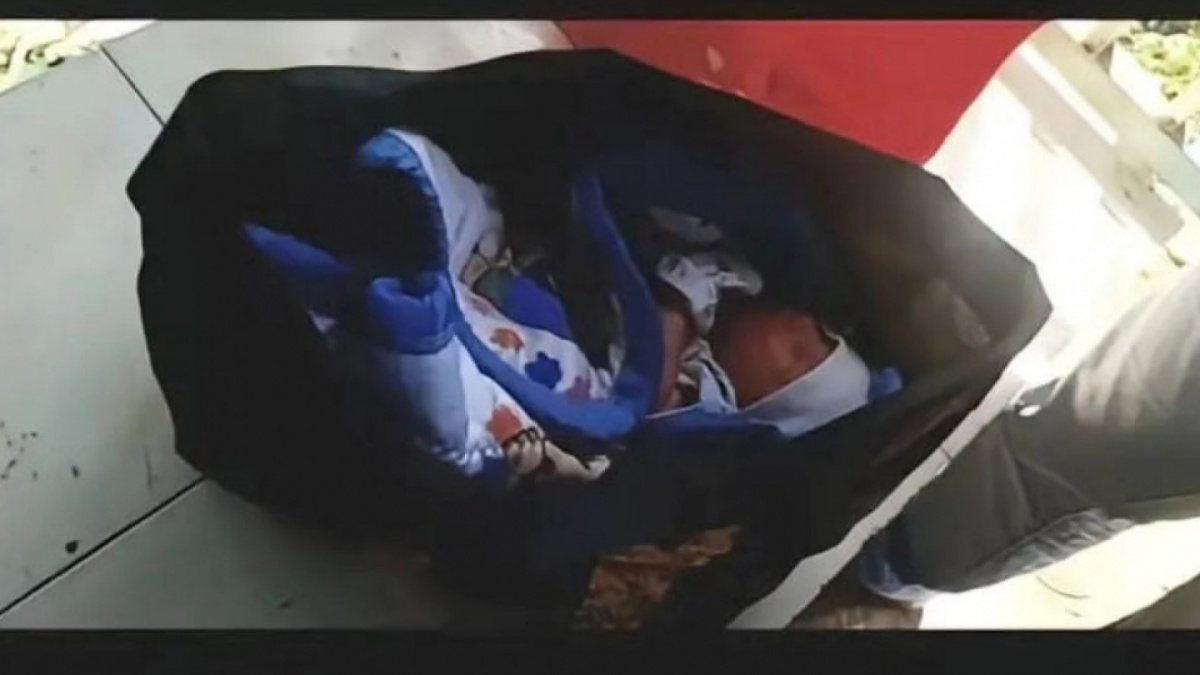 Foto seorang bayi perempuan dalam keadaan terbungkus selimut dalam kantong besar berwarna hitam yang ditemukan oleh pengendara motor di halte bus. [Instagram/drama.sosialmedia]