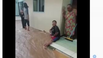 Viral, Aksi Lucu Seorang Pemuda Lakukan Hal Konyol Ini Agar Air Banjir Tidak Masuk Rumah