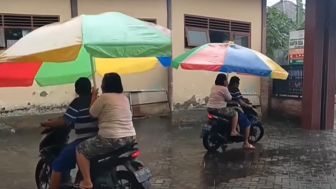 Kocak! Wanita Ini Pakai Payung Tenda Kafe saat Naik Motor Biar Gak Kehujanan, Nitizen: Pakai Teratak Aja Sekalian