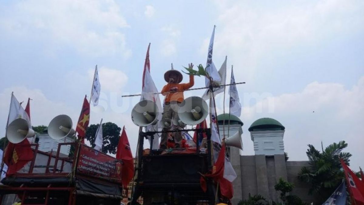 Pendemo aksi HTN 2022 di DPR berorasi menyentil aksi Kapolda Metro bagi-bagi roti dan air. (Suara.com/Arga)