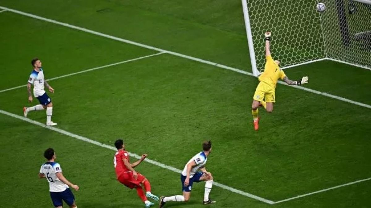 Penyerang Iran Mehdi Taremi mencetak gol melewati kiper Inggris Jordan Pickford selama pertandingan sepak bola Grup B Piala Dunia 2022 di Stadion Internasional Khalifa di Doha, Qatar. (21/11/2022) [(AFP)]